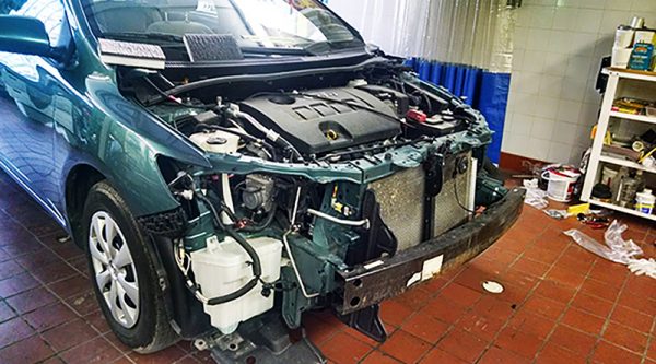 front end crash of green vehicle in Bob's Auto Body in Wisconsin